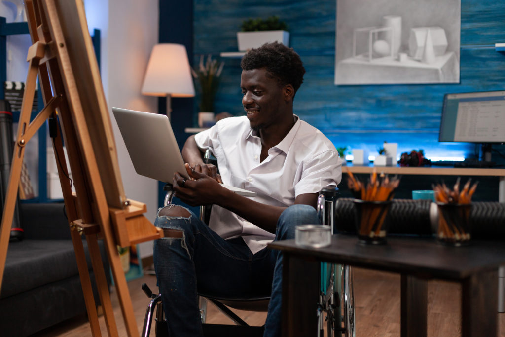 artist with disability holding laptop computer 2021 12 09 22 29 27 utc